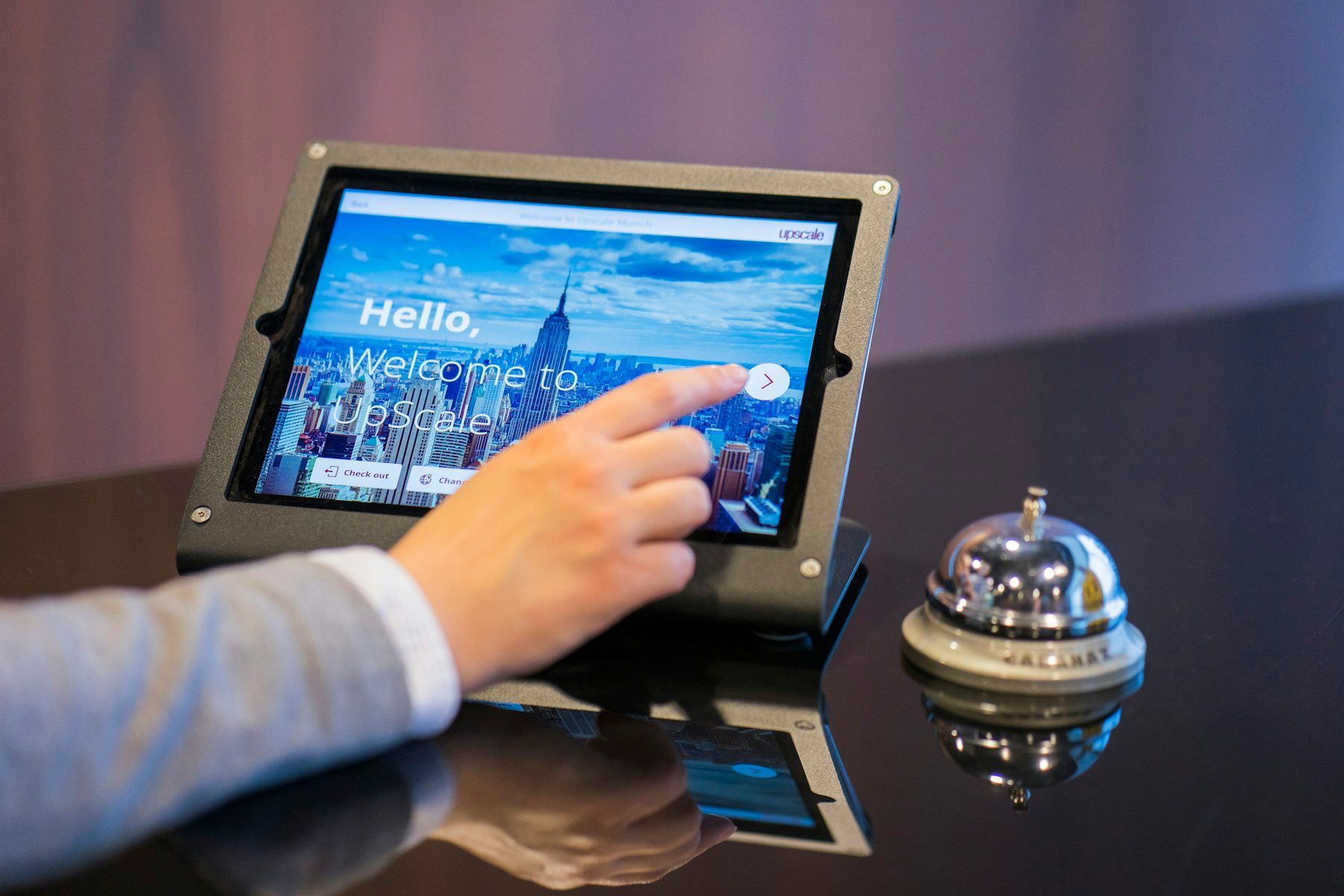 Person bedient ein Tablet an einem Empfangstresen.